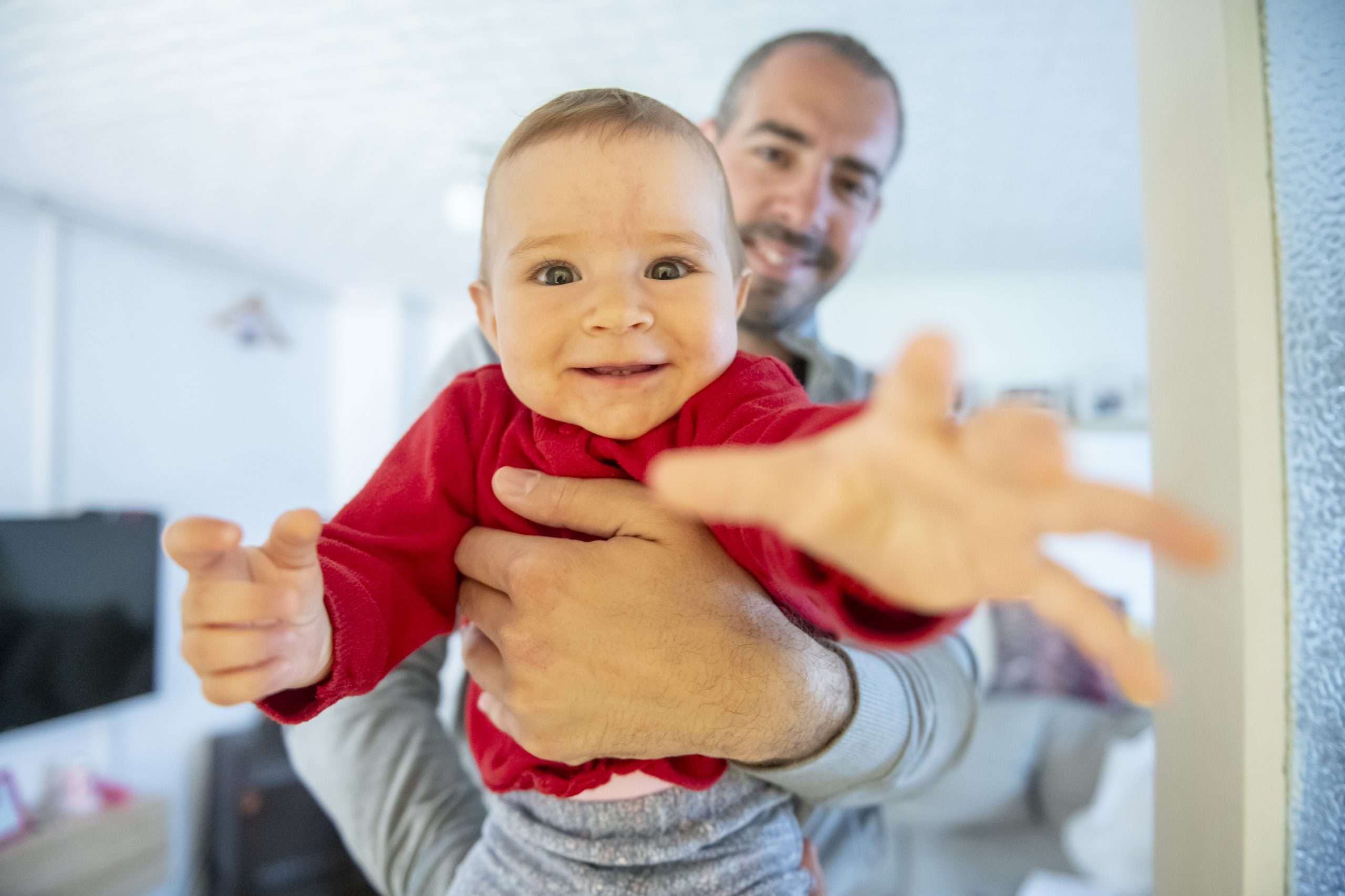 A man holding a playful baby.