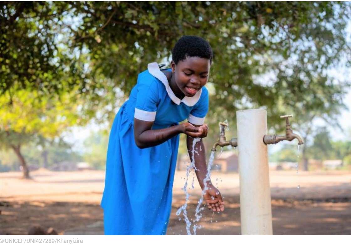 girl drinking water from pump in Malawi